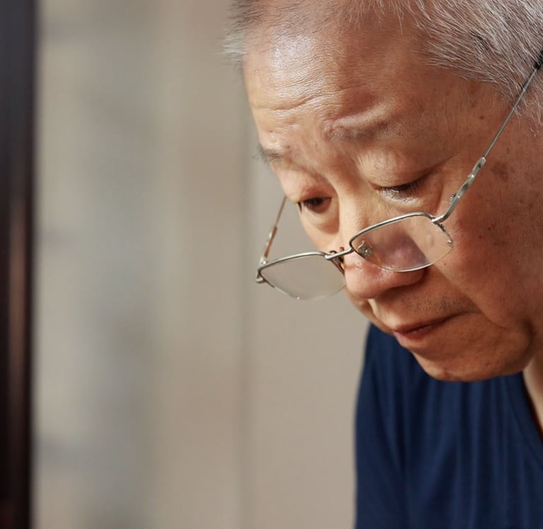 Close-up of artisan’s face, deeply focused while working on a teapot