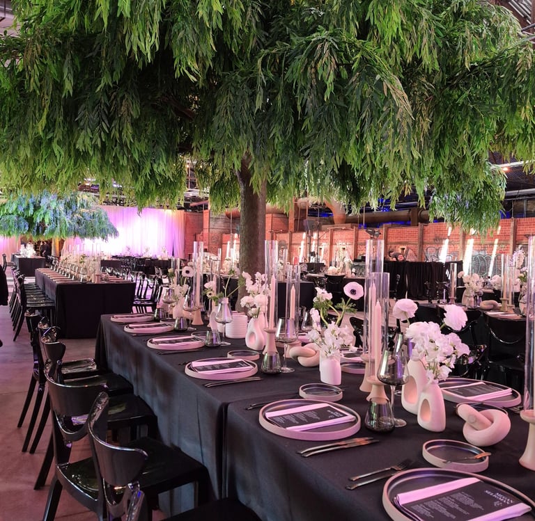 Fake tree in event space with beautiful table decorated of candle and flowers