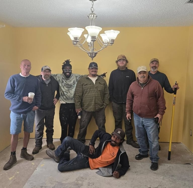 Members of the Suwannee Sunshine Services crew standing together inside a home during a project.