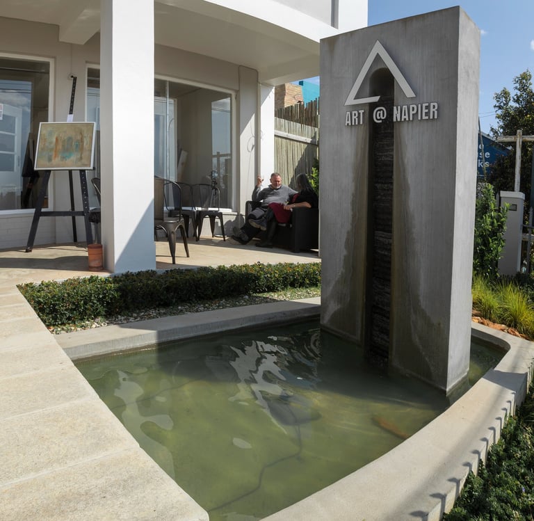 Entrance of Art at Napier Gallery with water feature and outdoor seating area.