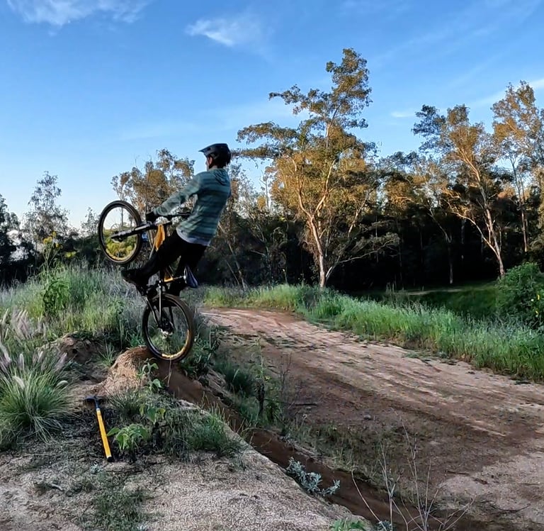 mountain biker pulling up off a jump when doing the boost technique