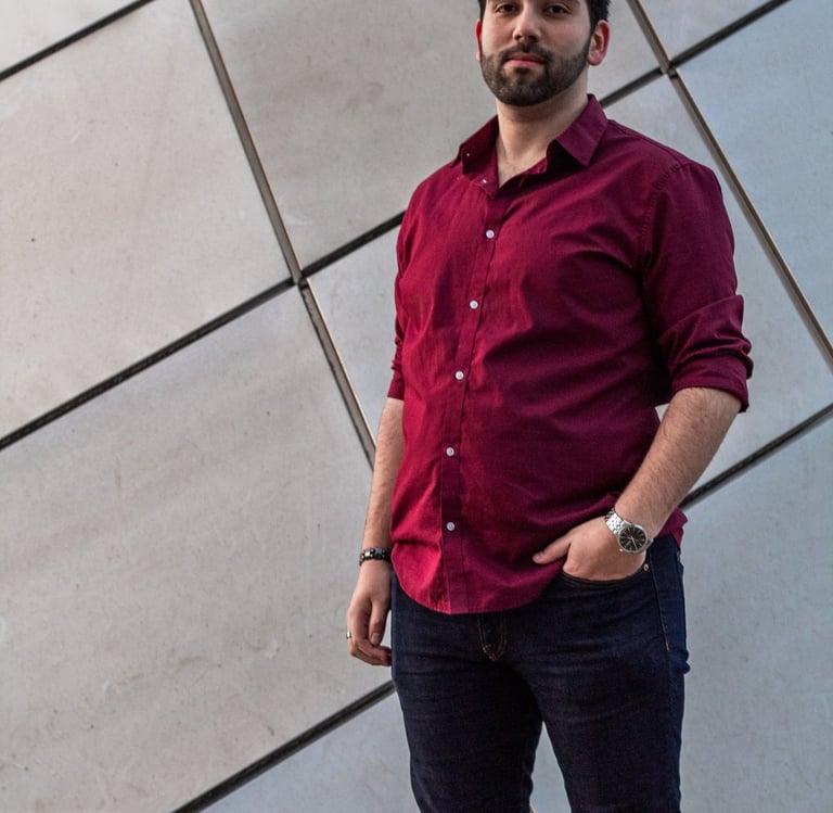 Wide picture of Manuel Tirado, wearing a red shirt and black pants.