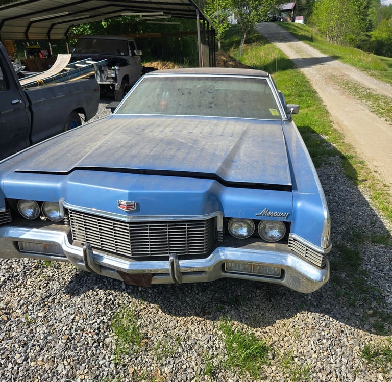 Blue classic car on a gravel driveway