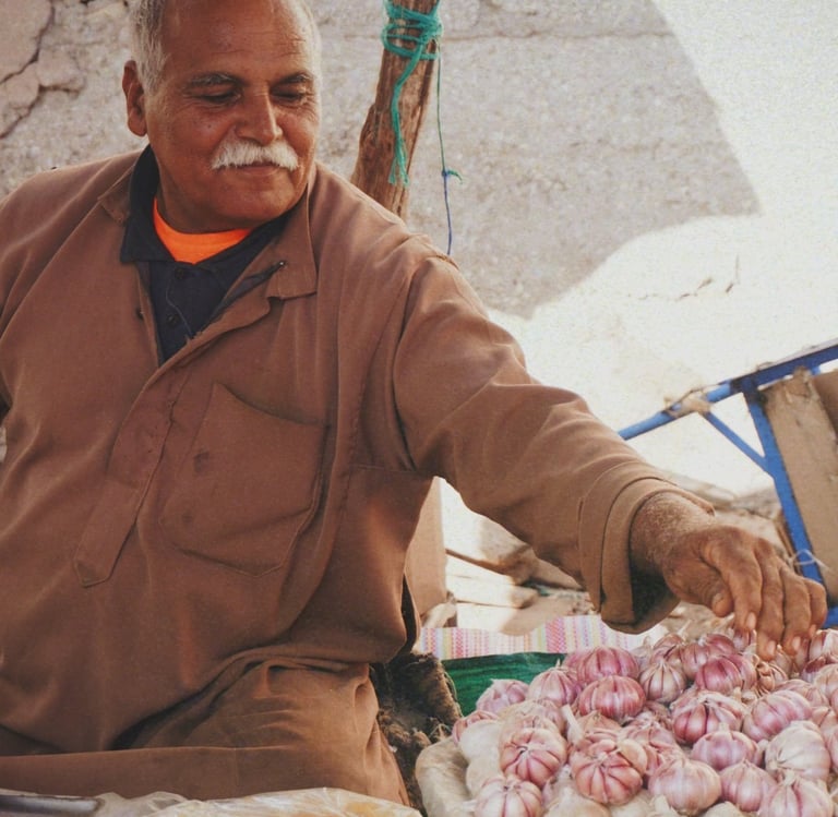 man in brown jacket selling spices in souk