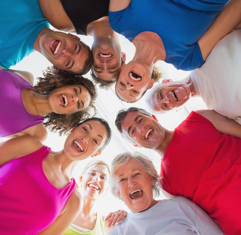 Low angle view of a diverse group of smiling people in fitness wear huddled together in a circle.