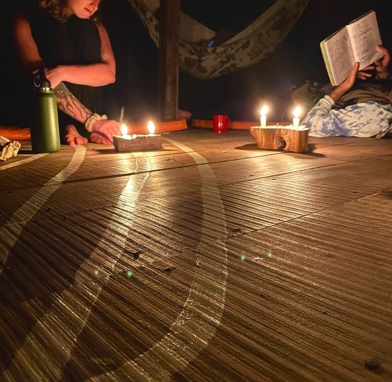 People reading by candlelight on a wooden deck in a bungalow in the Amazon Jungle.