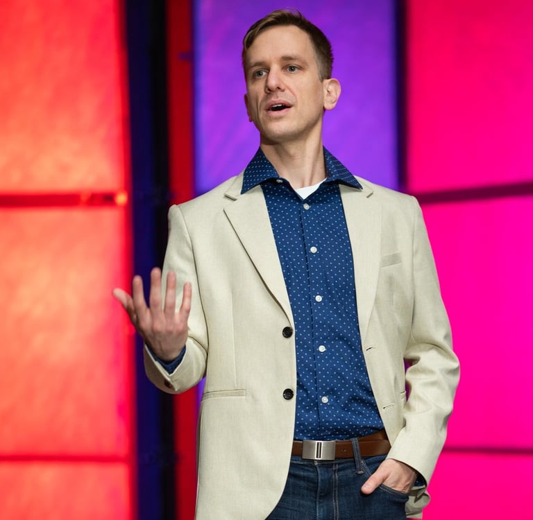 Remy stands on stage speaking