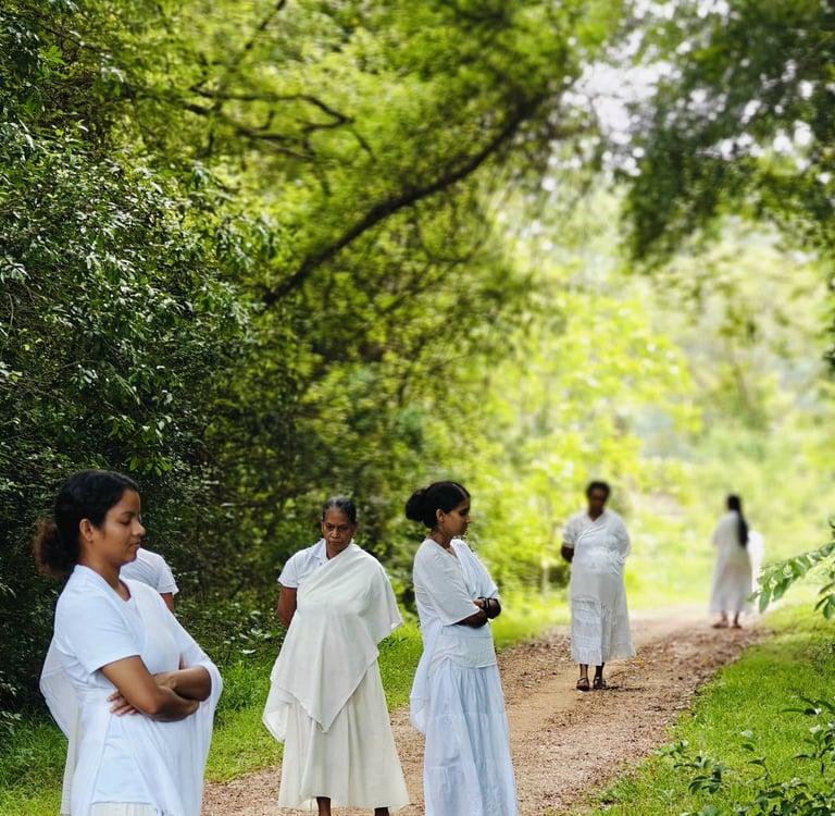 a group of people in white dresses walking down a path
