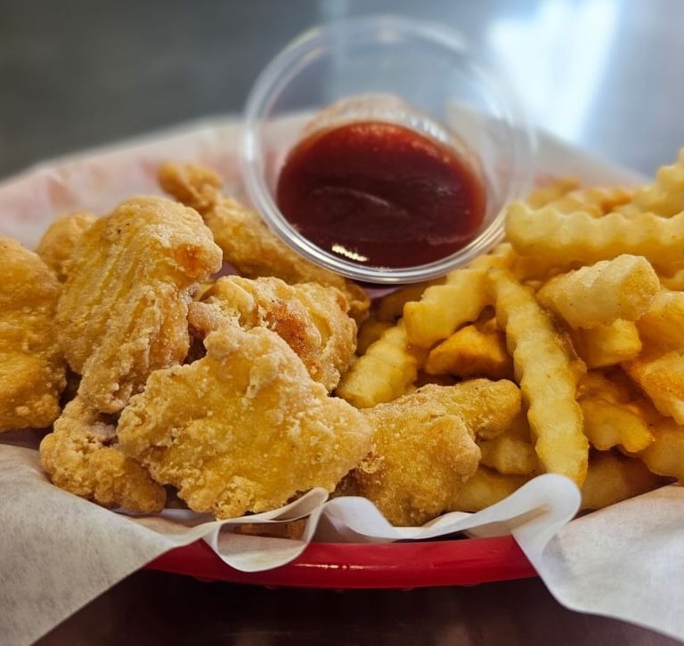Crispy fried chicken bites and crinkle cut fries with BBQ dipping sauce at Captain's Galley