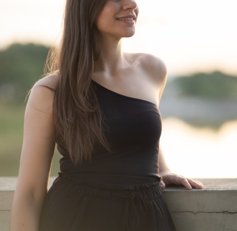 a woman in a black dress standing on a ledge