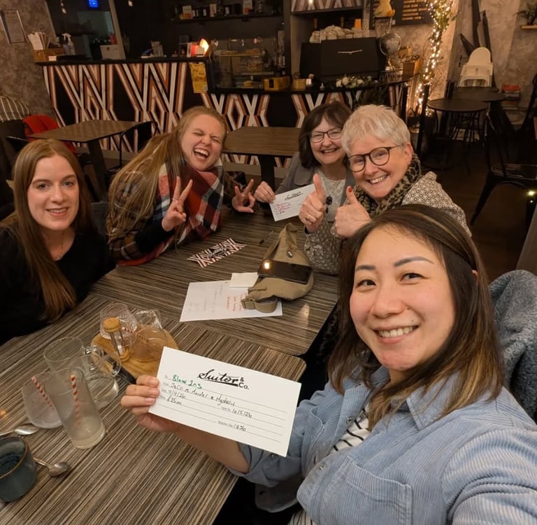 a group of women are smiling as they have won a quiz.