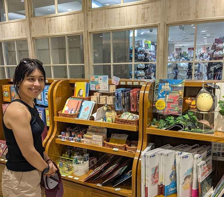 Traveler browsing Studio Ghibli souvenirs in Osaka, Japan.
