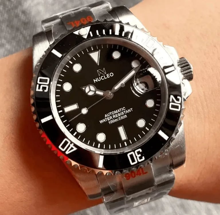 homage submariner acciaio quadrante e lunetta unidirezionale neri con data a ore 3 indossato al polso