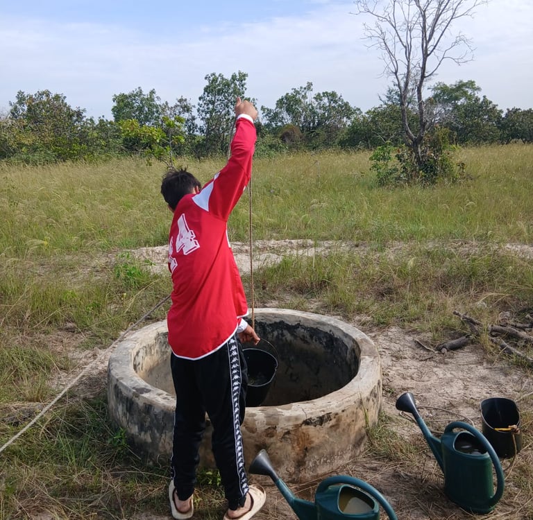 Photo d'un jeune accompagné par Bourokk et Kadiamor qui cherche l'eau dans le puit