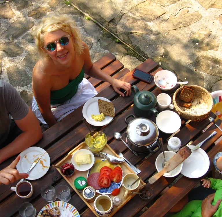 Rodzina delektująca się śniadaniem na świeżym powietrzu przy rustykalnym drewnianym stole