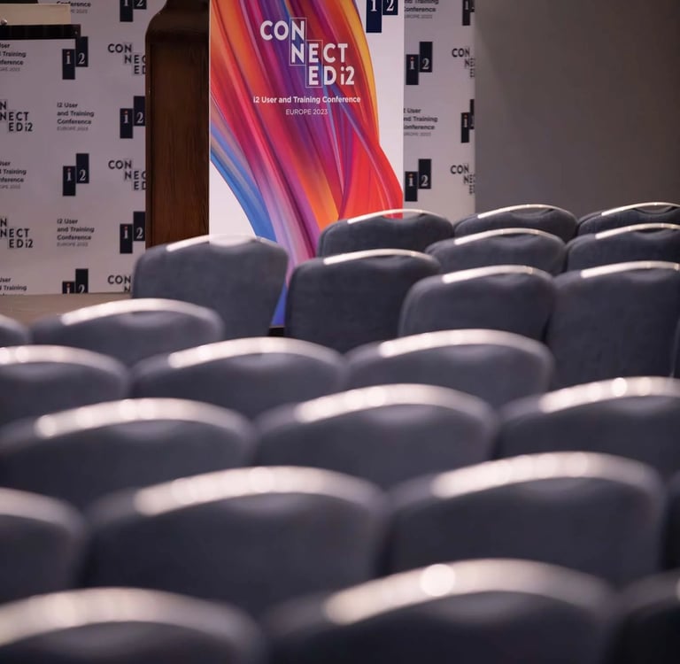 Podium and rows of empty chairs at the i2 User and Training Conference Europe 2023.