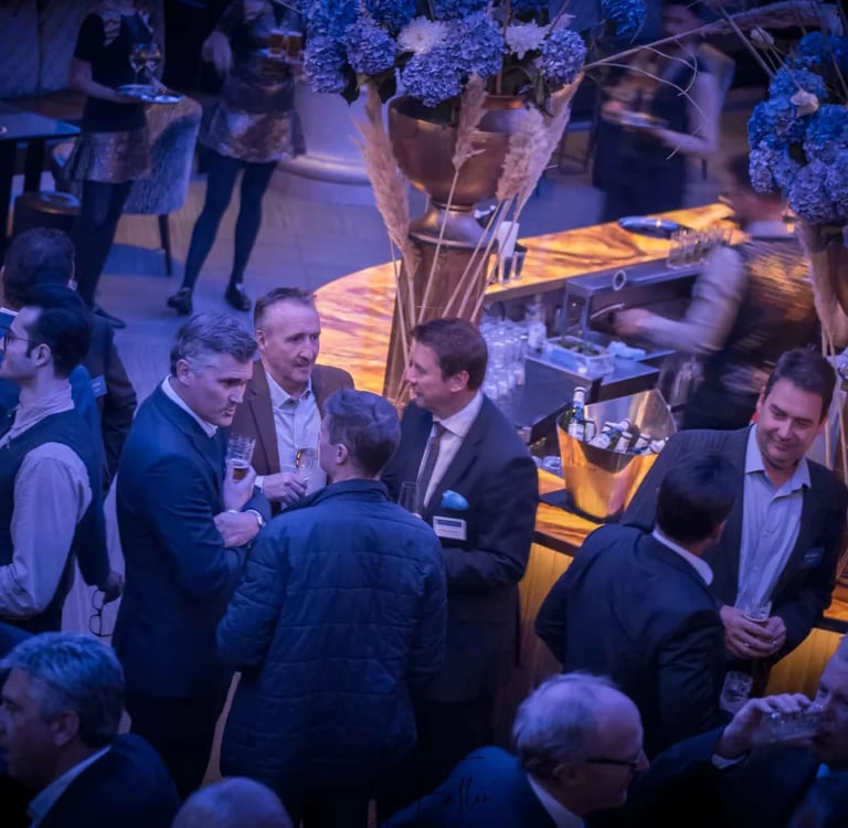 Professional networking event at a luxury hotel bar with guests in business attire.