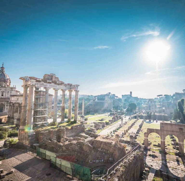 Panoramic view of the Roman Forum ruins in Rome under a bright sunny sky.
