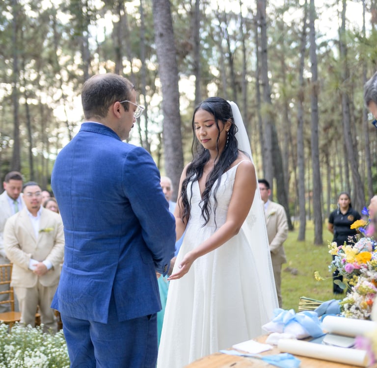 Pareja tomándose las manos, en ceremonia en medio del bosque. Foto: Victor King
