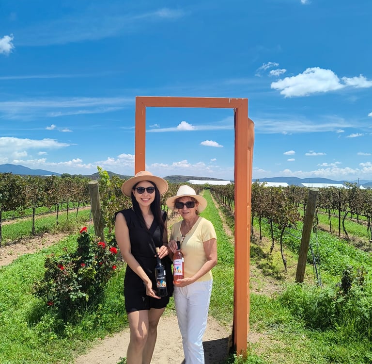 Dos mujeres con botellas de vino en viñedo de Querétaro, experiencia enológica