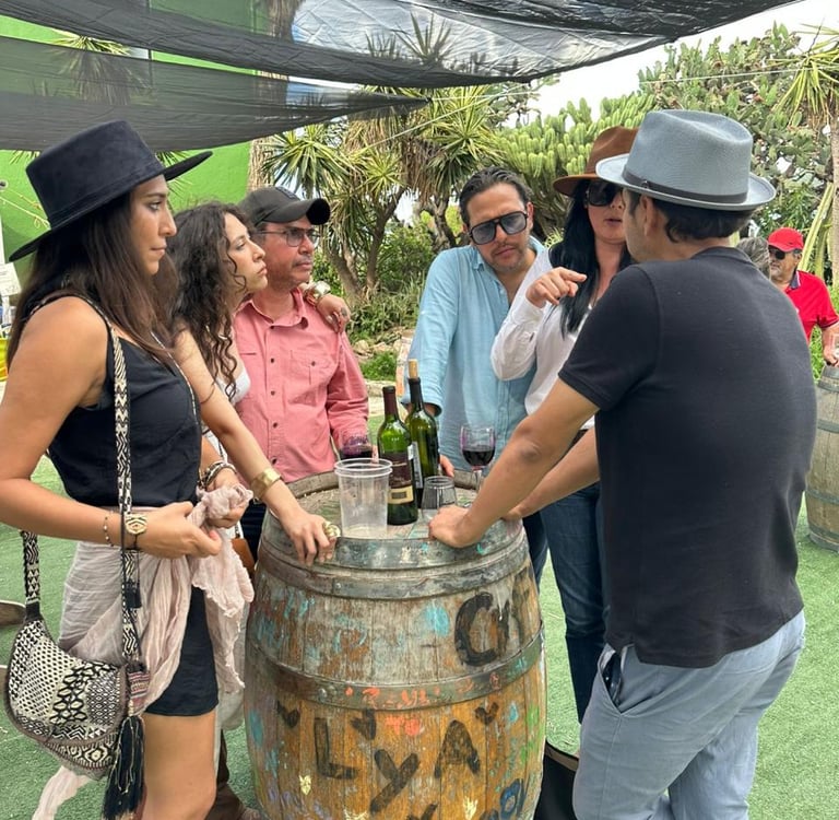 Grupo de amigos conversando junto a barril en viñedo de Querétaro