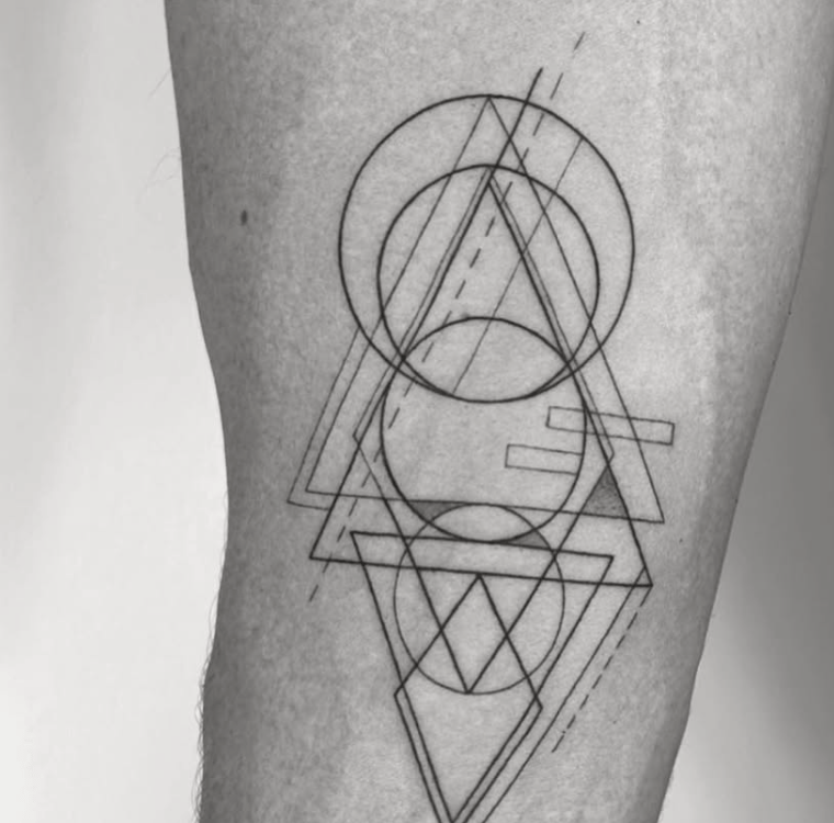 Tatuaje geométrico abstracto con triángulos y círculos superpuestos en pierna madrid