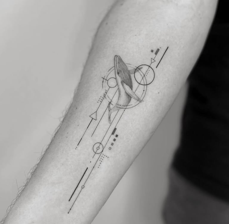 Tatuaje fineline ballena jorobada con elementos geométricos en antebrazo madrid