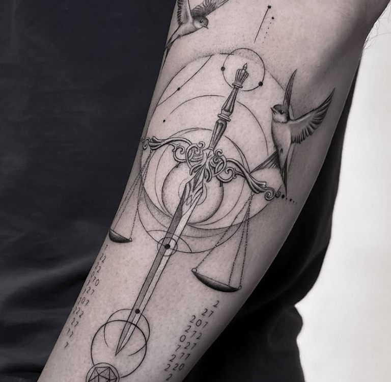 Tatuaje fineline balanza de la justicia con golondrinas en antebrazo madrid