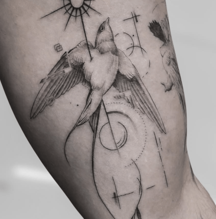 Tatuaje fineline golondrina en vuelo con sol y elementos geométricos madrid
