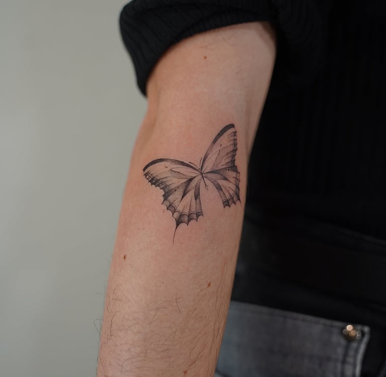 Tatuaje fineline en Madrid de mariposa con alas simétricas y detalle de venas en trazo fino madrid