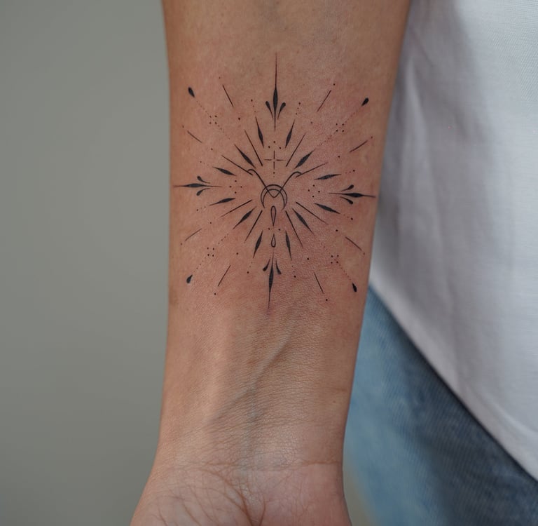 Tatuaje fineline ornamental en Madrid de estrella radiante simétrica con luna creciente cruz y detal