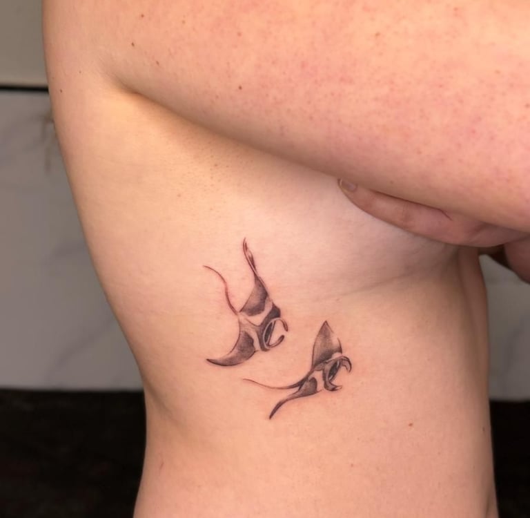 Tatuaje microrealismo en Madrid de dos mantas raya con sombreado realista en el costado