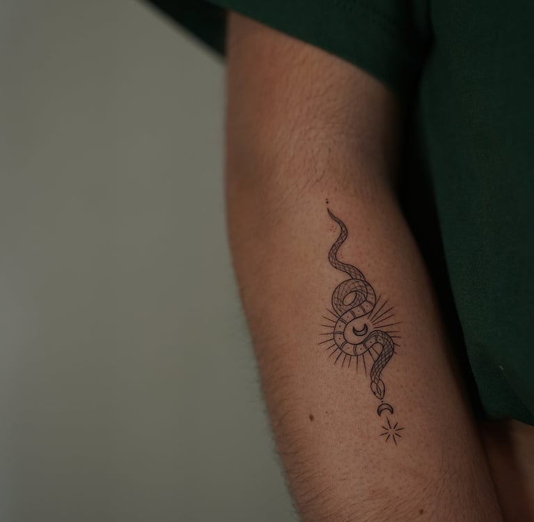 Tatuaje fineline en Madrid de serpiente mística enroscada en sol radiante con luna creciente