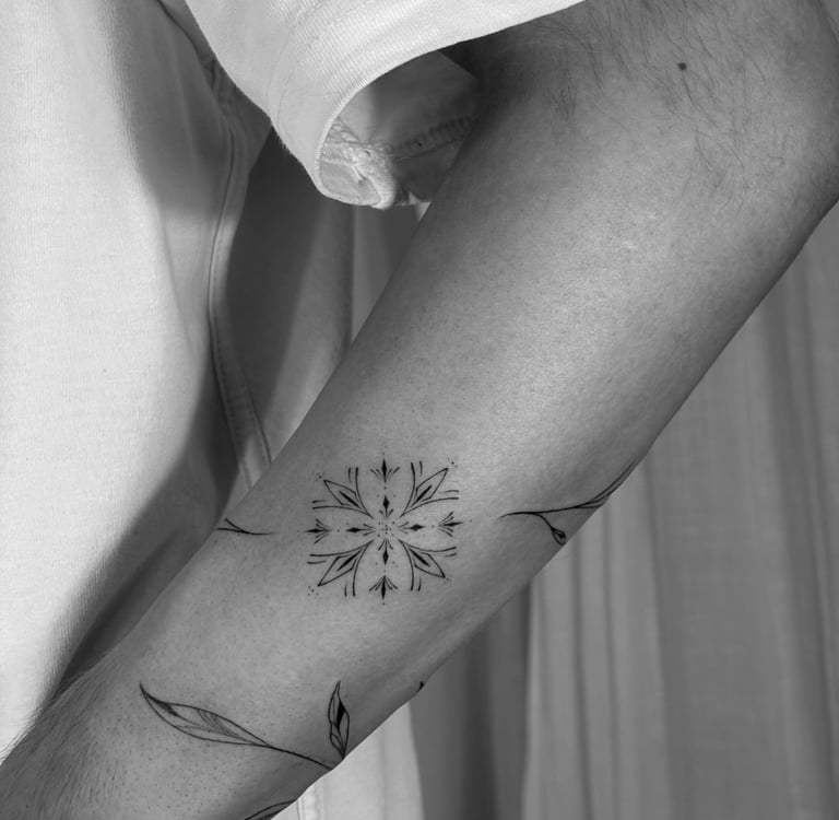 Tatuaje fineline ornamental en Madrid de mandala simétrico con ramas y hojas que se extienden