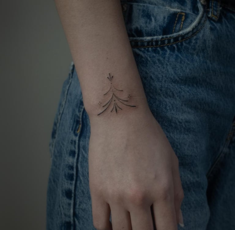 Tatuaje fineline en Madrid de composición abstracta con corazón y caligrafía gestual en línea contin