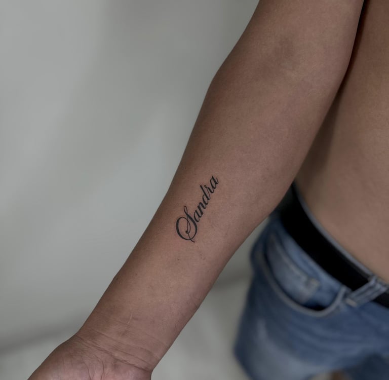 Tatuaje fineline en Madrid de nombre en caligrafía cursiva elegante en el antebrazo