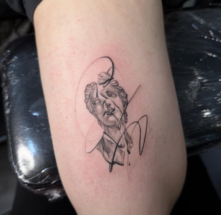 Tatuaje fineline en Madrid de busto clásico greco romano con trazos abstractos y líneas gestuales en