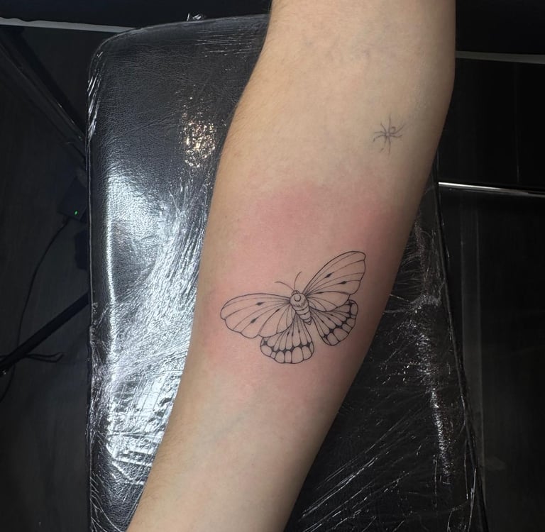  Tatuaje fineline en Madrid de mariposa nocturna con detalle entomológico acompañada del número 888