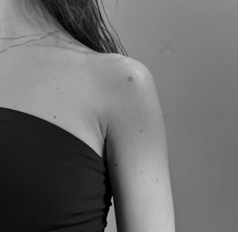 Tatuaje fineline en Madrid de estrella micro minimalista en trazo muy fino en el hombro