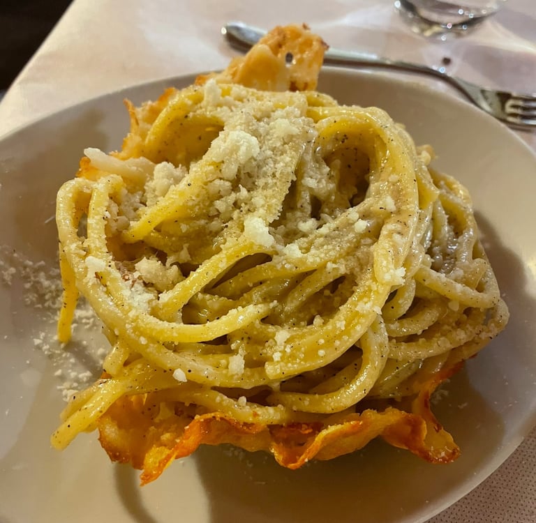 Authentic Italian Cacio e Pepe pasta served in a crispy Parmesan cheese bowl with cracked black pepper.