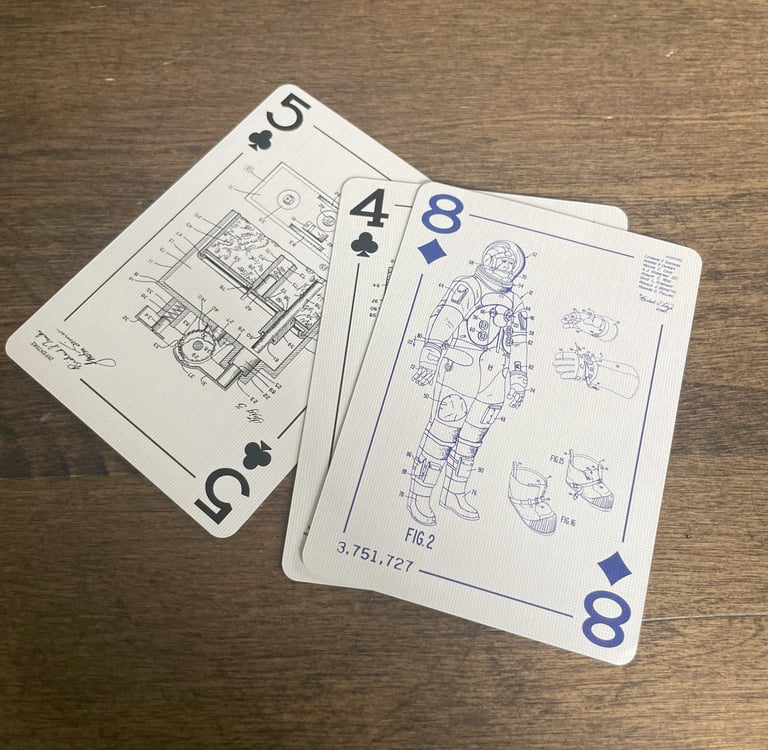 Five of Clubs, Four of Clubs, and Eight of diamonds showing engineering drawings from patents
