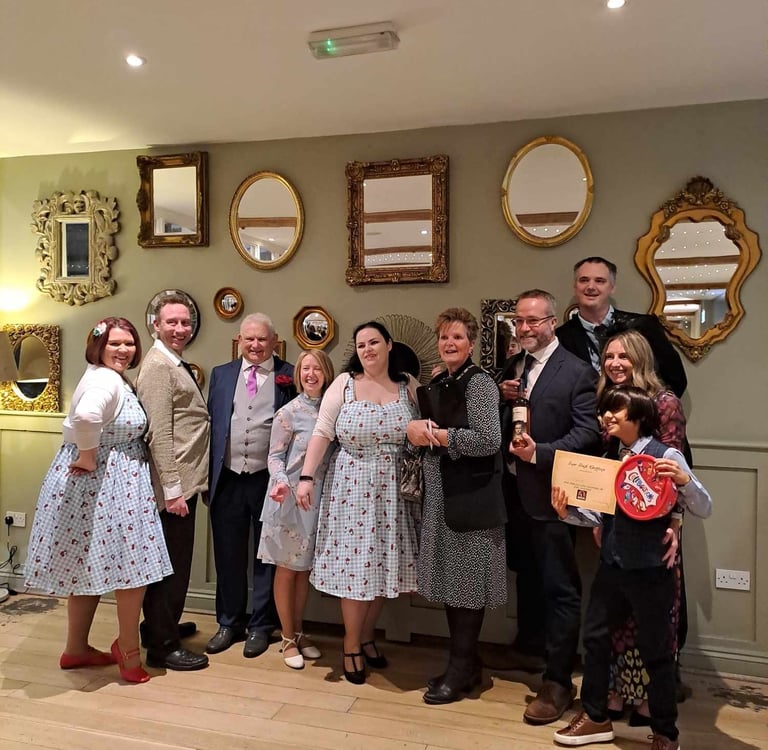 bride and groom with the cast and winners at the end of their wedding murder mystery