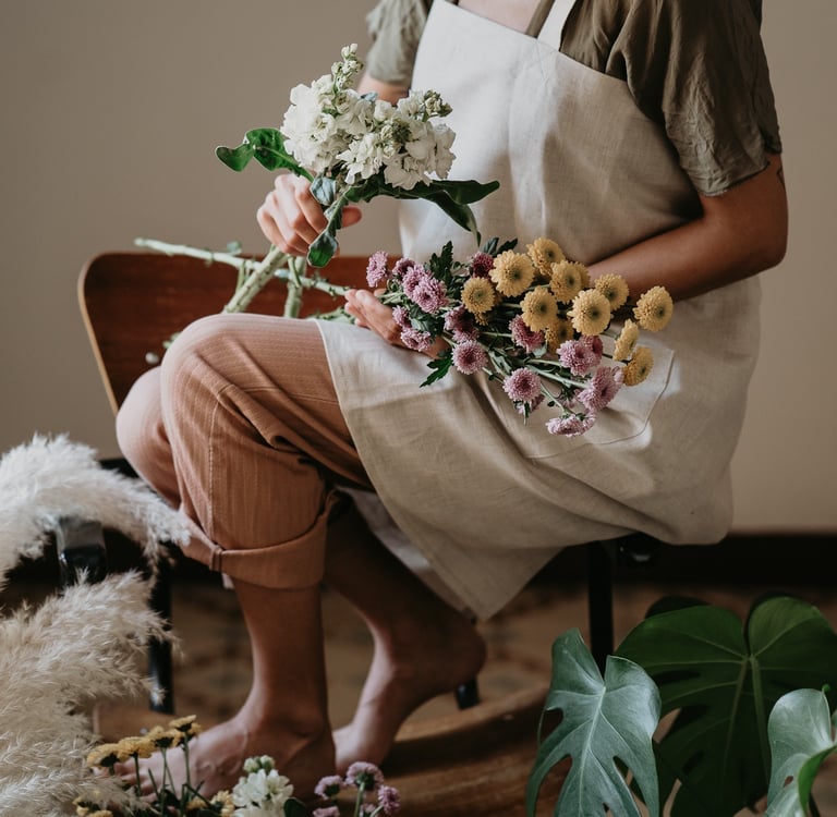 fotografía corporativa de una mujer con un delantal japonés de brie y un ramo de flores