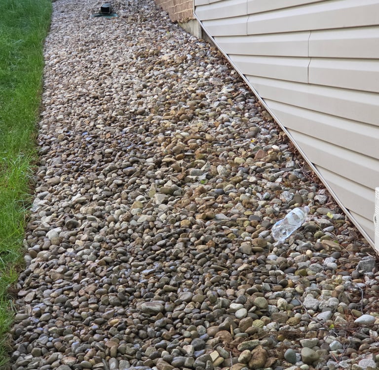 Gravel bed installed along house foundation for drainage and erosion control