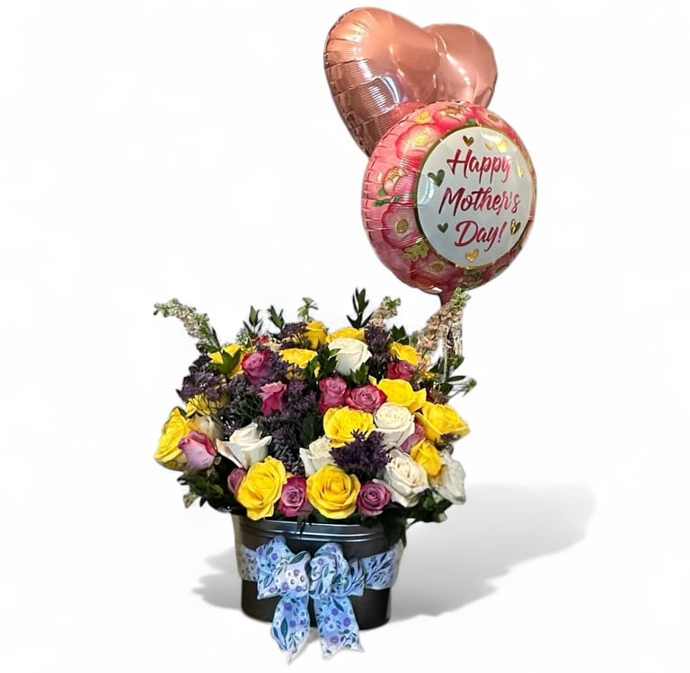 Floral arrangement for mothers day.  Main flowers are pink, yellow, and white roses