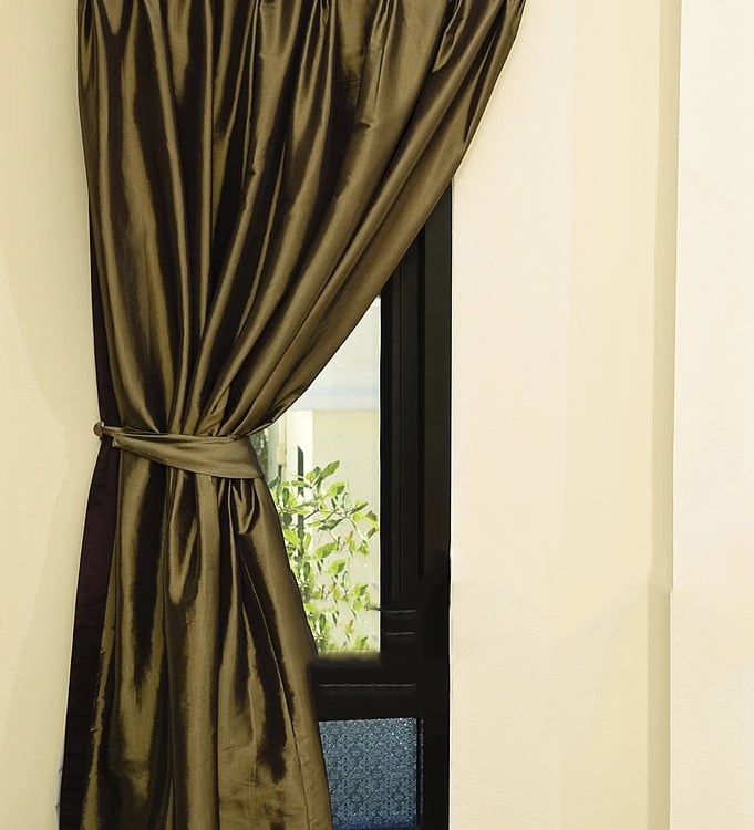 Rideau satiné vert aux triple plis et embrase sur une fenêtre mince