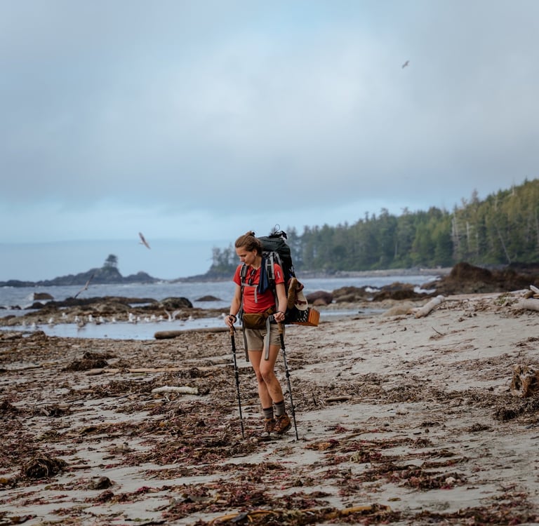 a man with a backpacker walking on a beach