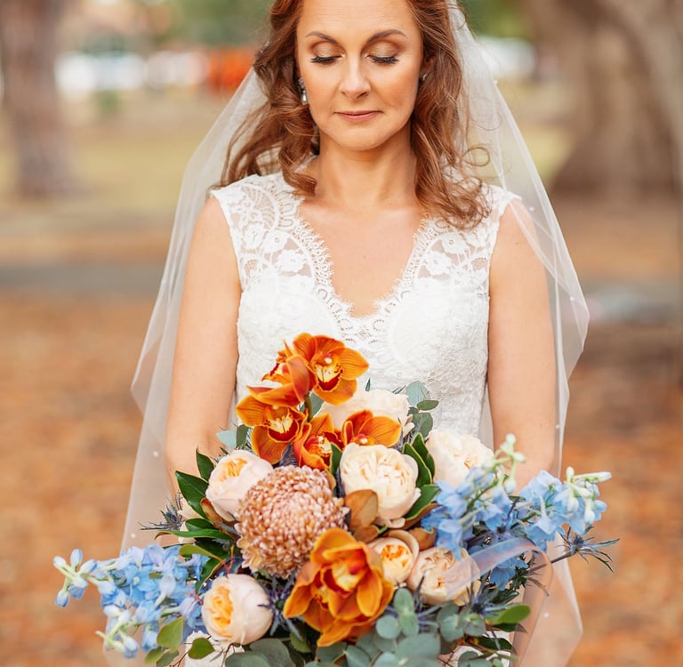 a bride in a white wedding dress holding a bouquet