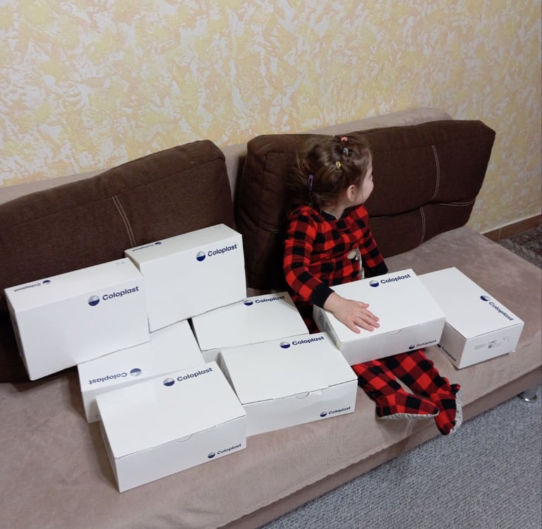 маленька дівчинка сидить на дивані з ящиками коробок