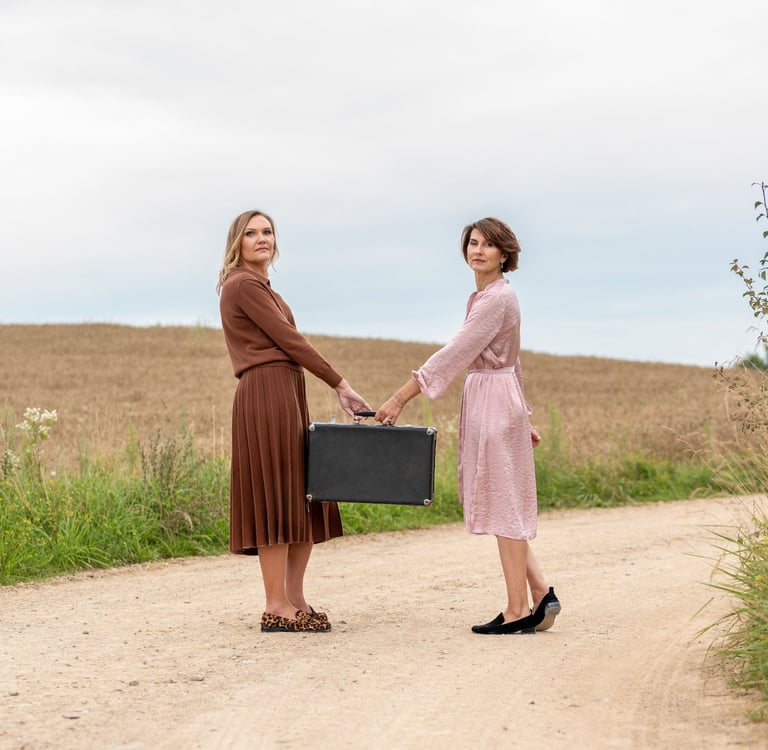 two women shaking hands on a dirt road